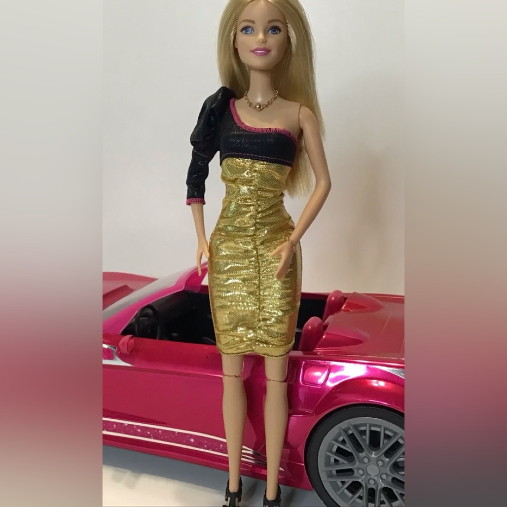 Barbie with gold and black dress and black shoes.